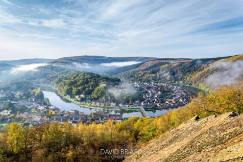 Photo d'automne de la ville de Monthermé dans les Ardennes, enveloppée d'une brume légère vue depuis la Roche à 7 heures © David Briard