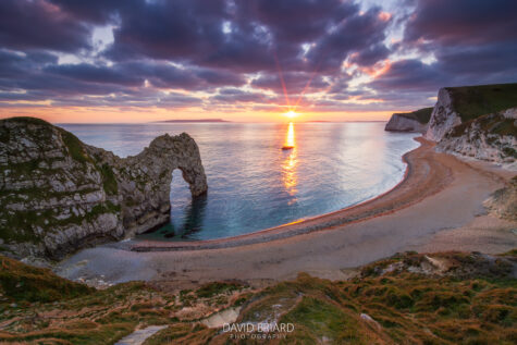 Le soleil se couche derrière la célèbre Durdle Door, une arche de calcaire naturelle située sur la côte jurassique en Angleterre.